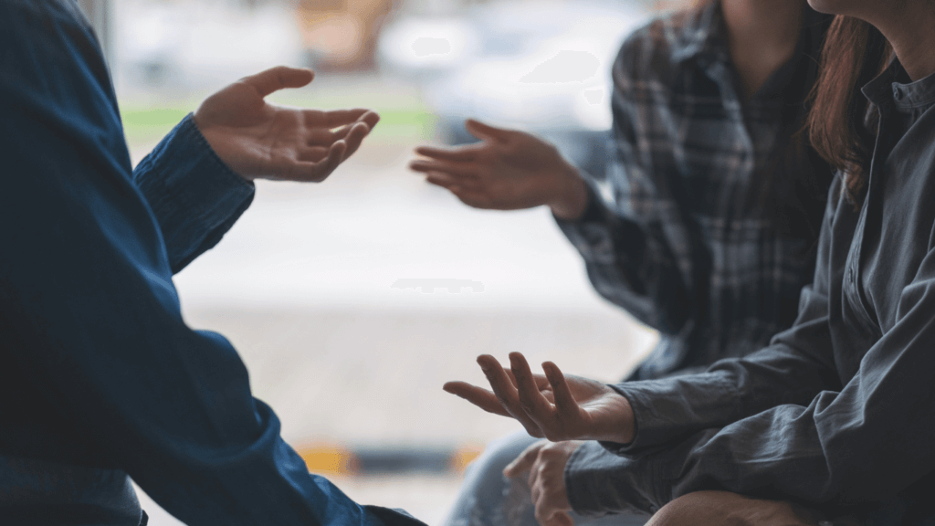 An image showing a group of people engaged in a conversation, with one person asking discovery questions to learn more about the topic at hand.